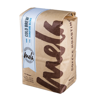 Kraft paper coffee bag wrapped with a light blue label reading Cold Brew Blend from Mela Coffee.