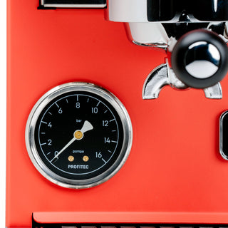 Close up of red Profitec GO espresso machine showing pressure gauge and portafilter lever.