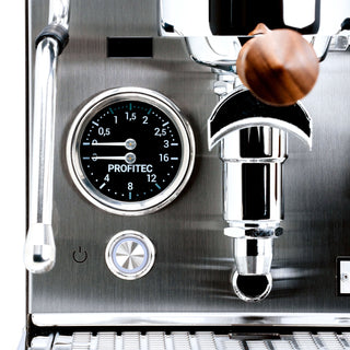 Close-up of Profitec JUMP control area with dial gauge, steam wand, and wooden portafilter handle.