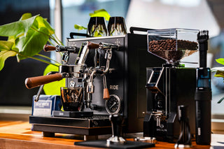 Close up of Profitec RIDE espresso machine front with dual group heads and wooden portafilter handles