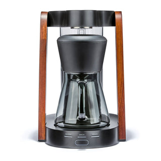 Close up of Ratio Eight Series 2 coffee maker with wood side frames, glass carafe, and black top