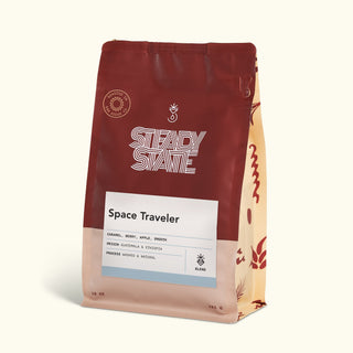Space Traveler coffee bag in burgundy packaging with a white label and striped side panel.