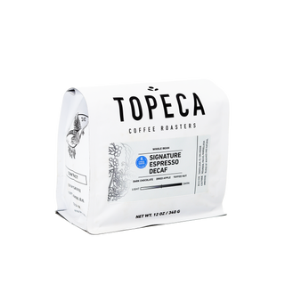 Angled white Topeca Signature Espresso Decaf coffee bag with Swiss Water logo and bold TOPECA branding