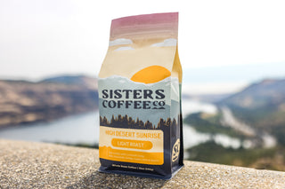 High Desert Sunrise coffee bag with sunlit desert mountains design photographed outdoors.