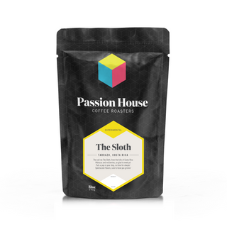 Black coffee bag with a colorful geometric cube logo and a bright yellow label reading The Sloth