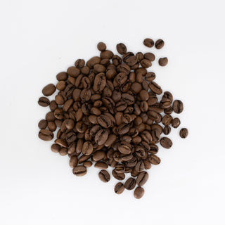 Roasted coffee beans scattered on a white surface