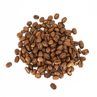 Pile of roasted coffee beans scattered on a white surface