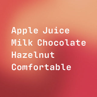 Teal Armando Quinteros coffee bag with red label listing Apple Juice Milk Chocolate Hazelnut on a warm orange gradient background.