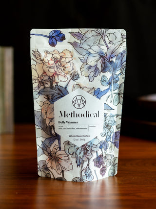 Belly Warmer whole bean coffee bag by Methodical Coffee with bold floral pattern.