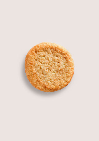 Round golden brown cookie centered on a pale beige background