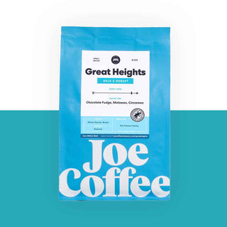 Bright blue coffee bag labeled Great Heights with bold Joe Coffee branding against a teal backdrop