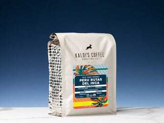 Kaldi's Coffee white packaging bag featuring the Peru Rutas del Inca label against a deep blue sky