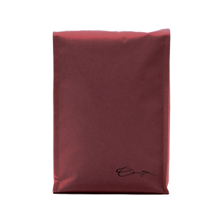 Deep burgundy coffee bag with a small black handwritten signature logo in the lower right