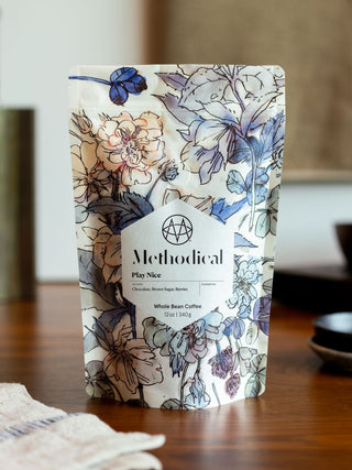 Play Nice whole bean coffee bag by Methodical Coffee with blue floral packaging.