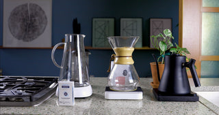 Brewing station with glass coffee carafe on a scale and a Third Wave Water box in the foreground